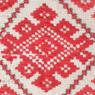 Close-up of one embroidered rhombus with a small dotted rhombus on top, a dotted centre and hooks on both sides