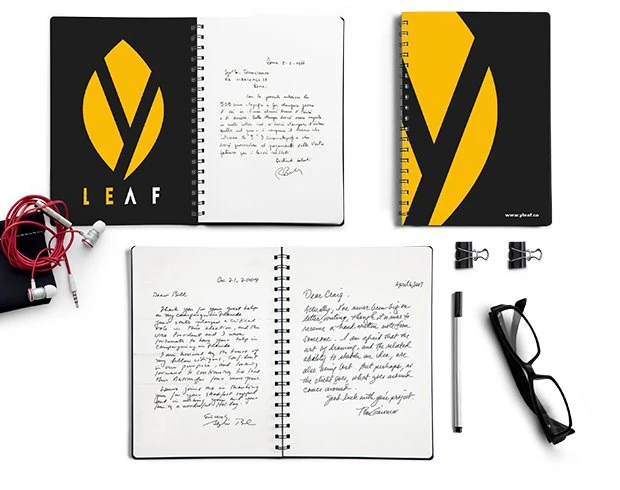 Black notebooks with the yellow leaf logo and the LEAF wordmark, one with a large cropped y on the cover